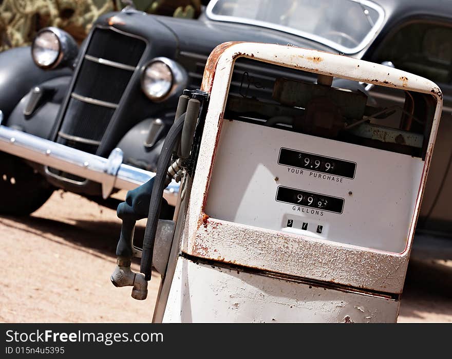 A vintage car awaits a vintage gas pump. A vintage car awaits a vintage gas pump