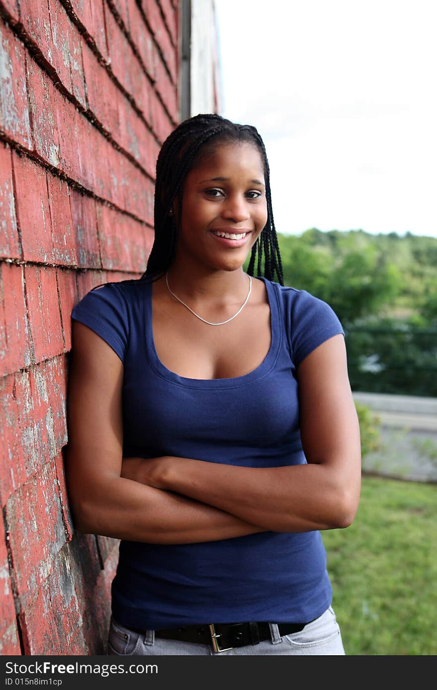 Pretty teen standing against red weathered shingles. Pretty teen standing against red weathered shingles