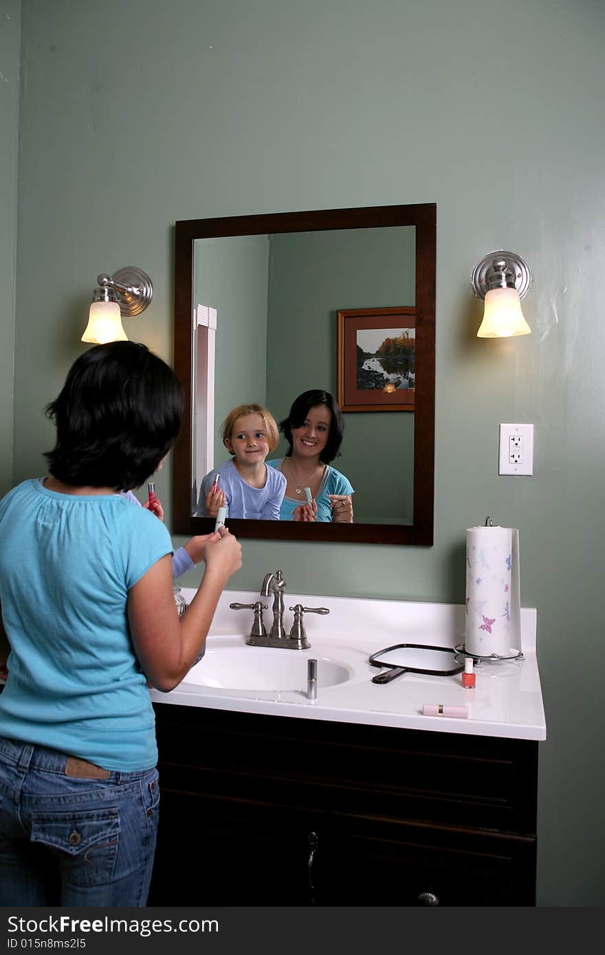 Two girls looking into mirror with makeup