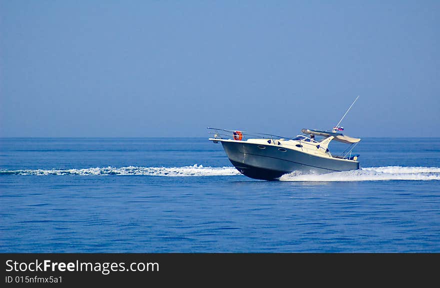 Photo of small fast cutter gliding at the sea surface