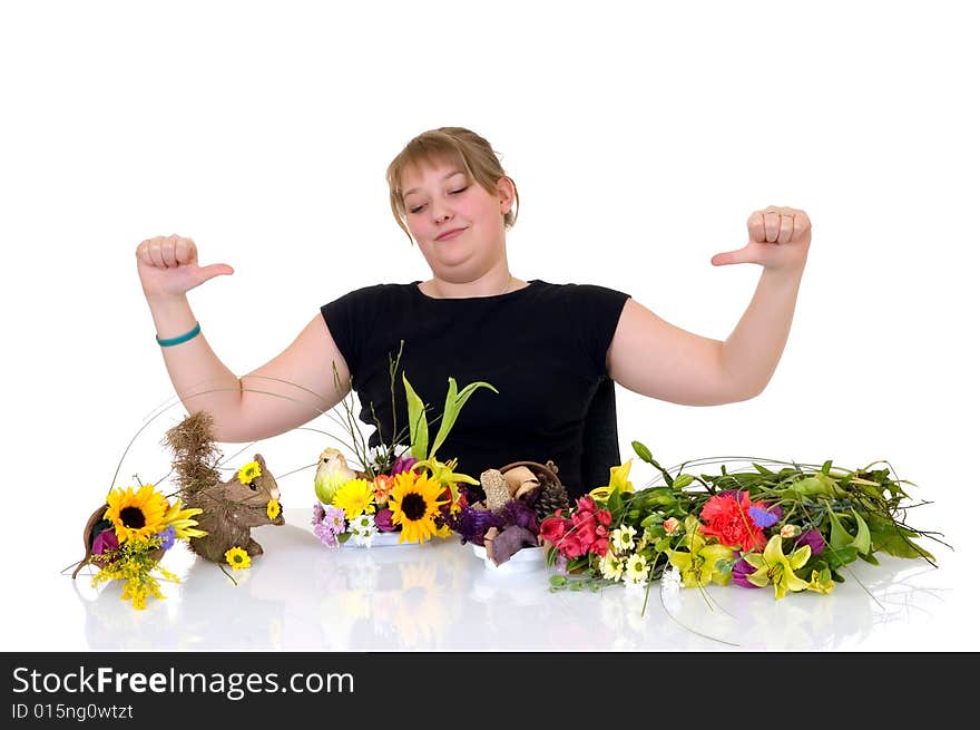 Young girl arranging flowers on reflective surface, white background, studio shot