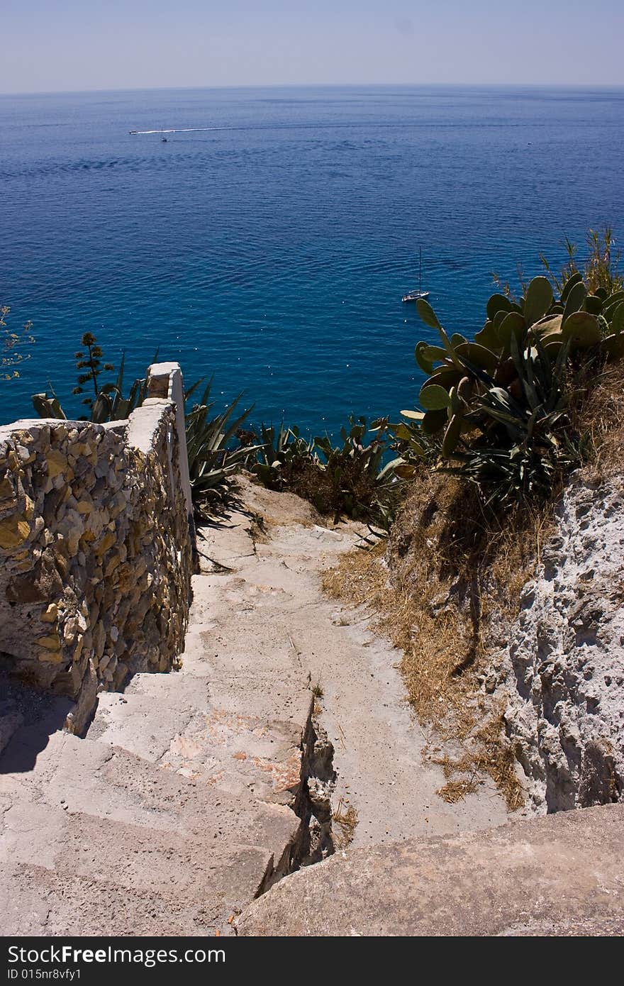 Stoned stairs leading down  to the blue sea. Ponza island, Italy. Stoned stairs leading down  to the blue sea. Ponza island, Italy