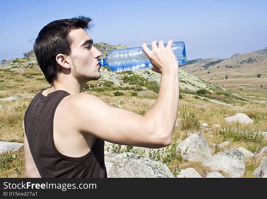 Boy drinking water in the mountain