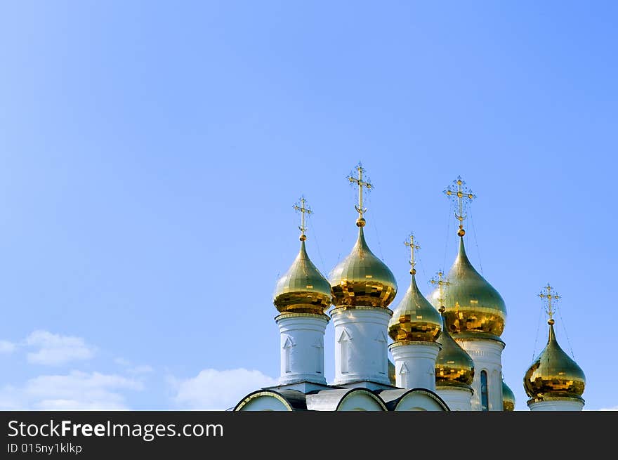 Golden church domes on blue sky background