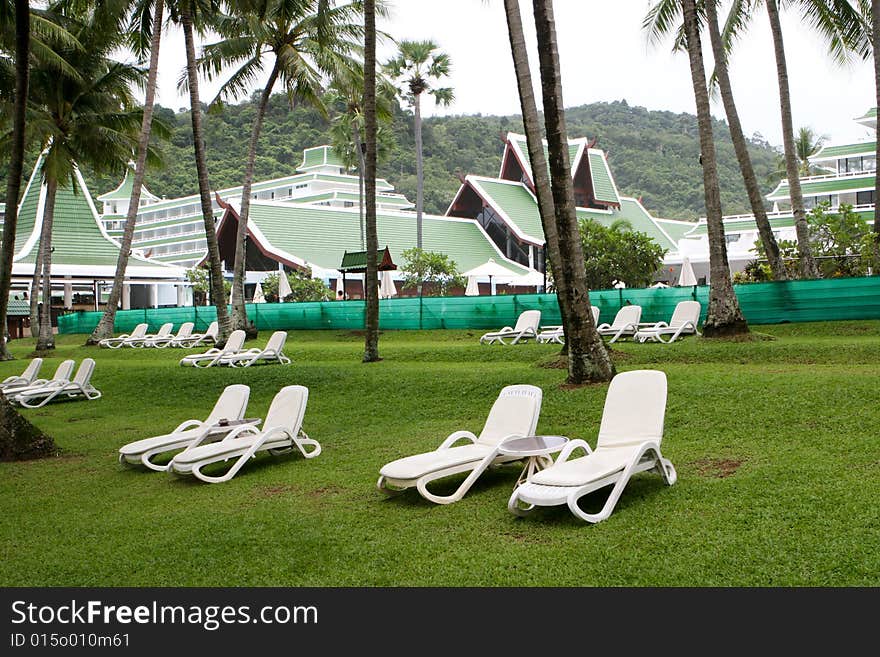 Deck chairs on the lawn at a tropical resort.