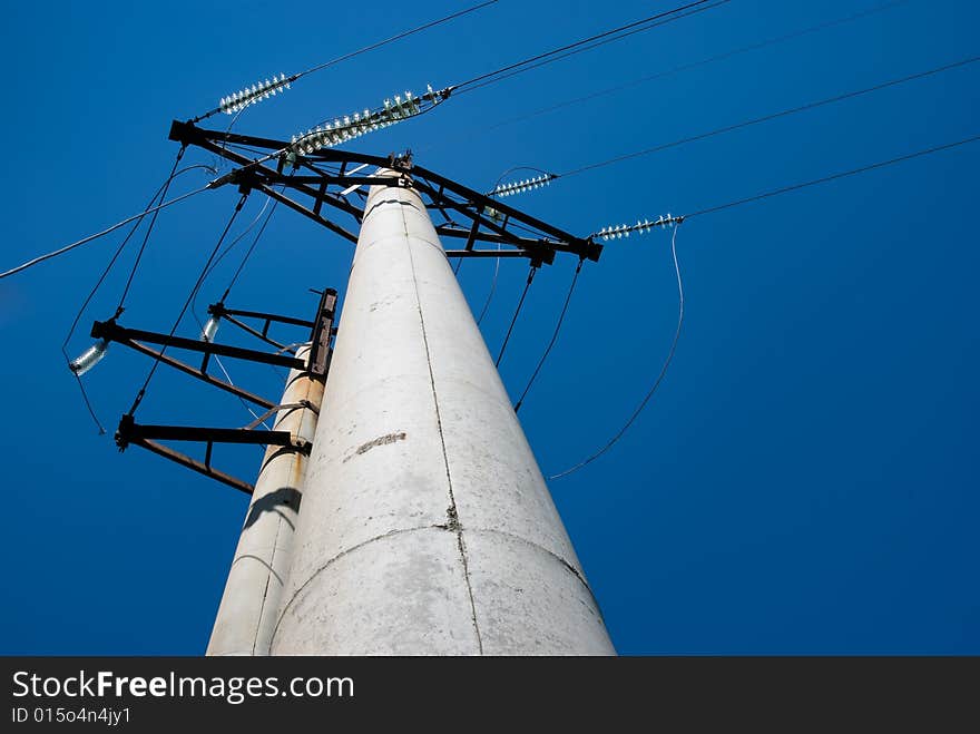 High voltage electric pillar against blue sky