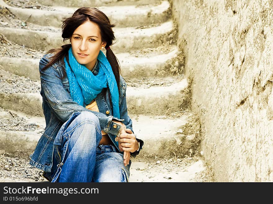 Young staring woman sitting on stone stairs. Young staring woman sitting on stone stairs.