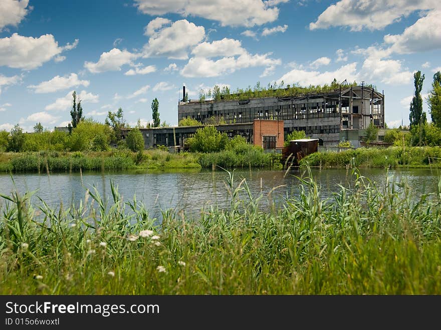 Abandoned chemical factory building with broken windows. Beautiful nature around it. Abandoned chemical factory building with broken windows. Beautiful nature around it.