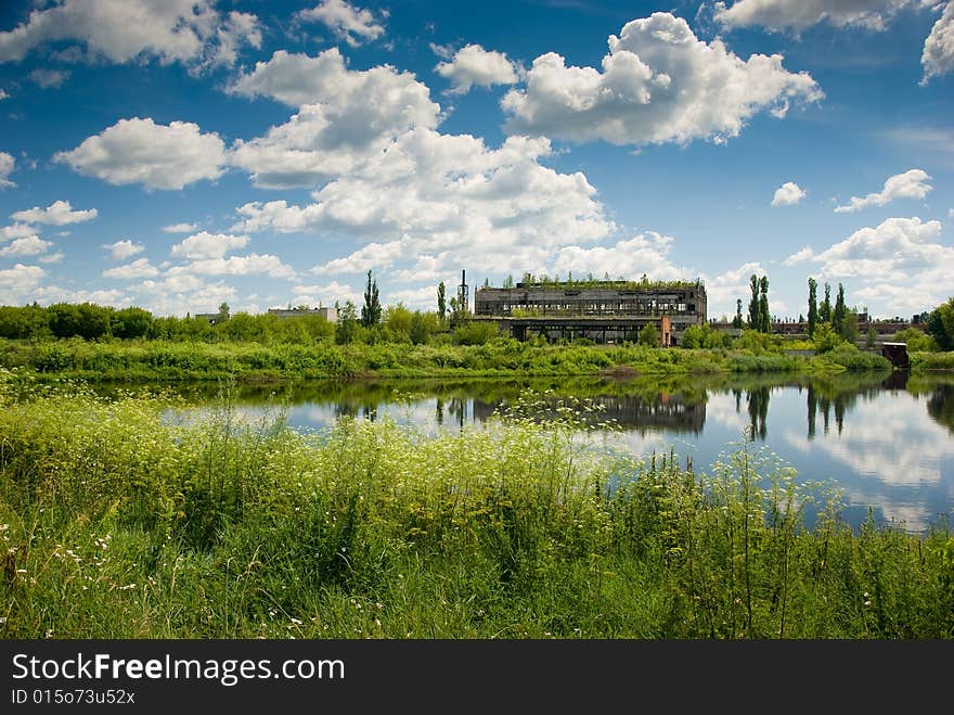 Abandoned chemical factory building with broken windows. Beautiful nature around it. Abandoned chemical factory building with broken windows. Beautiful nature around it.