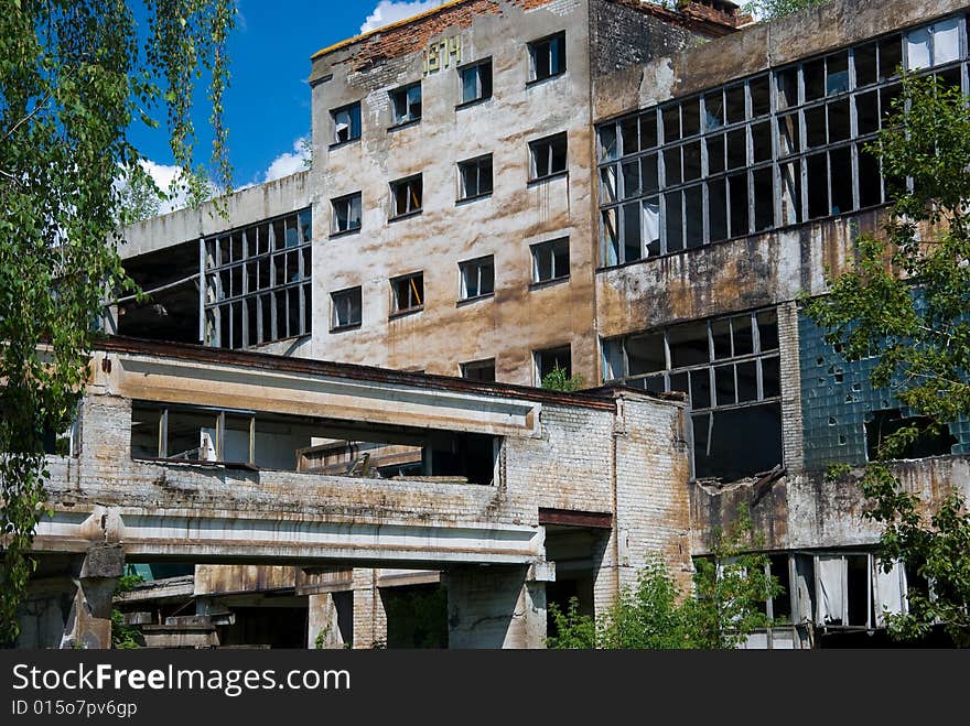 Abandoned chemical factory building with broken windows.