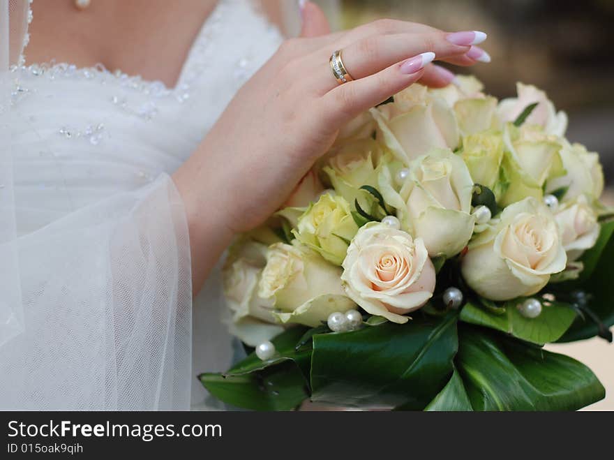 Hands of bride holding wedding bouquet with roses. Hands of bride holding wedding bouquet with roses