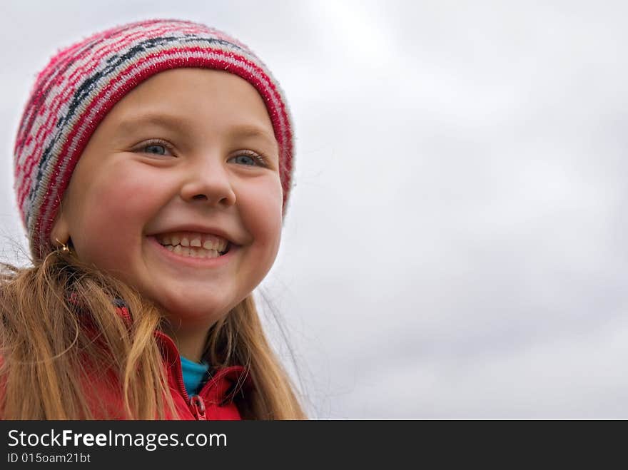 Young girl in a rose cap on a background sky. Young girl in a rose cap on a background sky