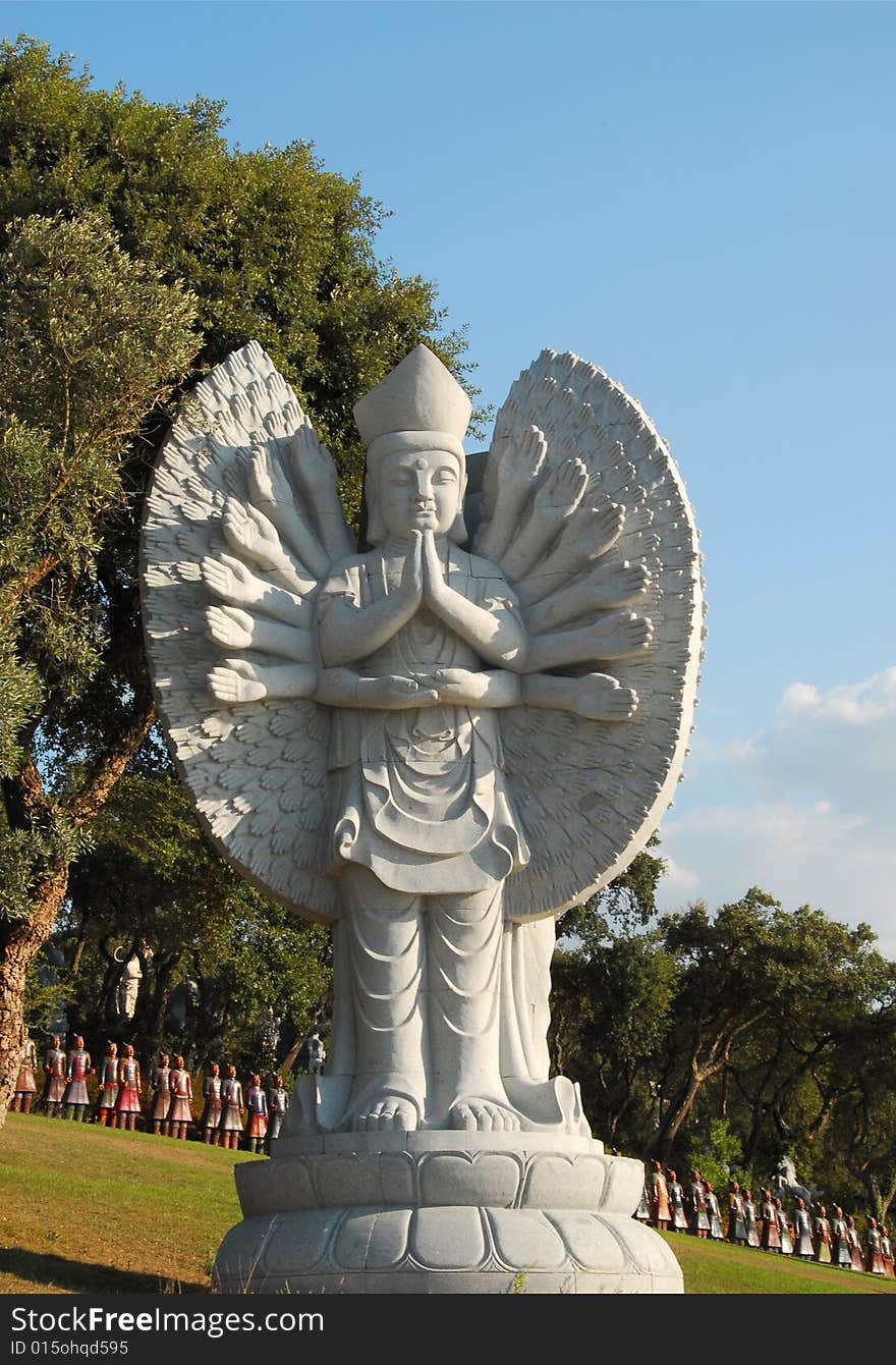 Buddha in the eastern garden with the soldiers in the background, in Qta. Of Loridos, Bombarral, Portugal. Buddha in the eastern garden with the soldiers in the background, in Qta. Of Loridos, Bombarral, Portugal