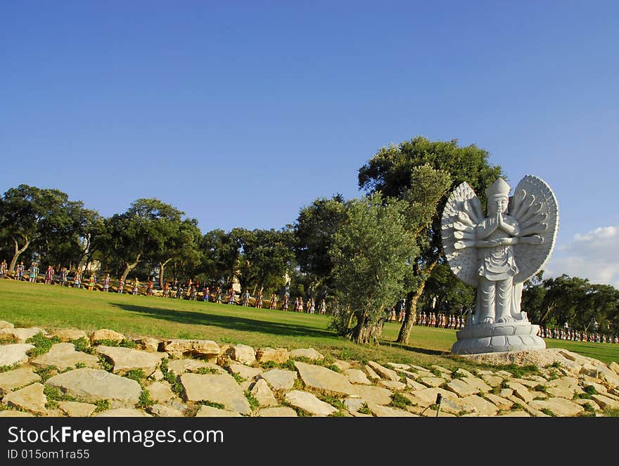 Buddha in the eastern garden with the soldiers in the background, in Qta. Of Loridos, Bombarral, Portugal. Buddha in the eastern garden with the soldiers in the background, in Qta. Of Loridos, Bombarral, Portugal