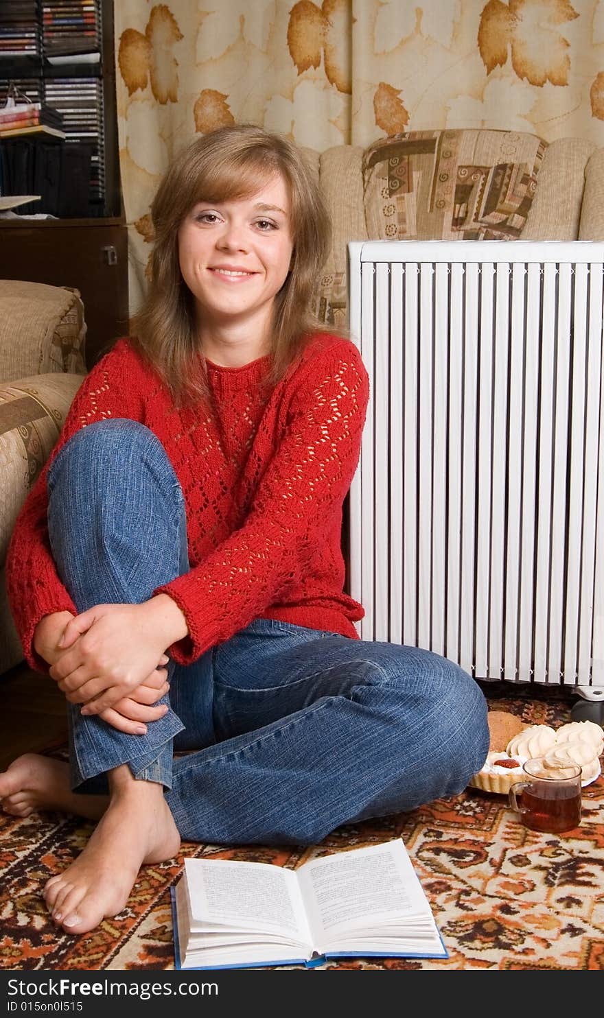 Woman sits on a carpet in a living room. Woman sits on a carpet in a living room