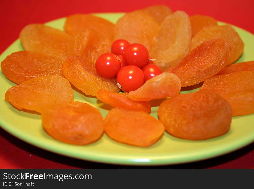 Plate of apricots with red berries in the middle. Plate of apricots with red berries in the middle