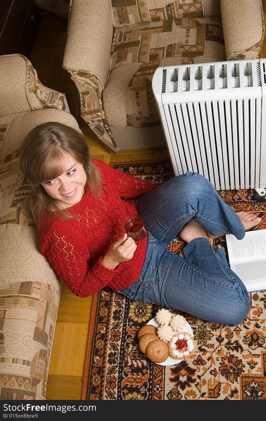 Woman sits on a carpet in a living room. Woman sits on a carpet in a living room