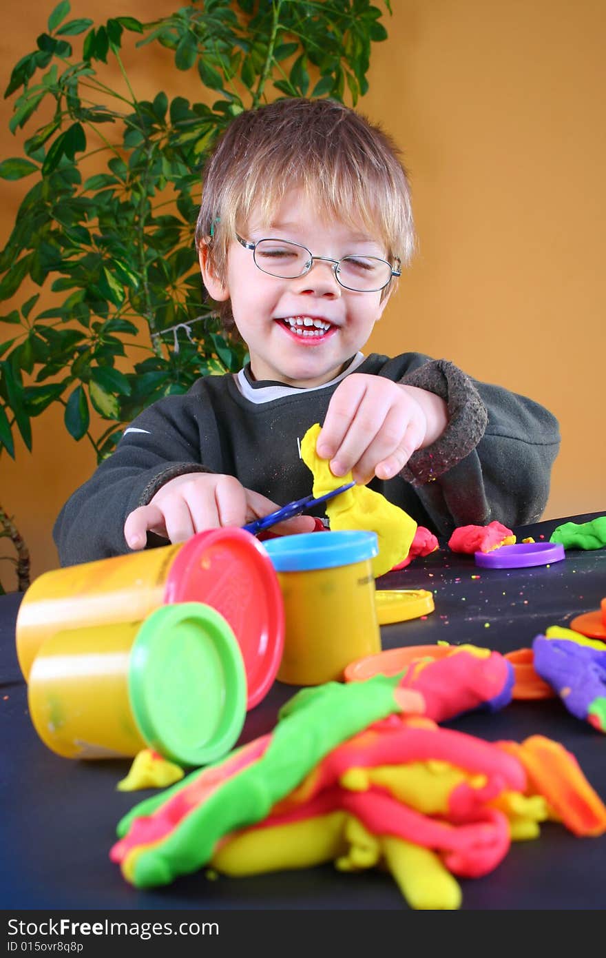 Young cute boy playing with plasticine. Young cute boy playing with plasticine