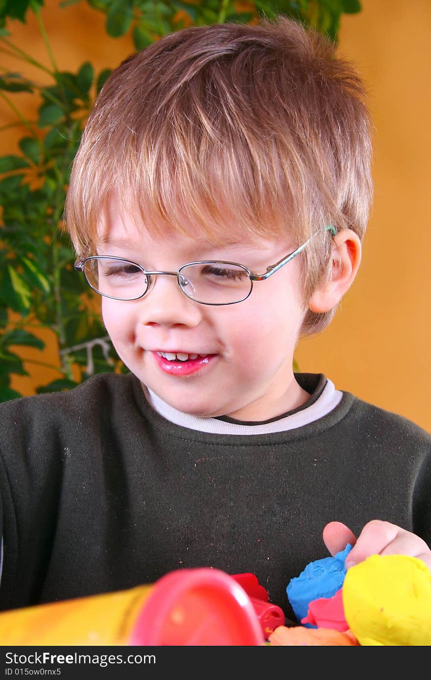 Young cute boy playing with plasticine. Young cute boy playing with plasticine