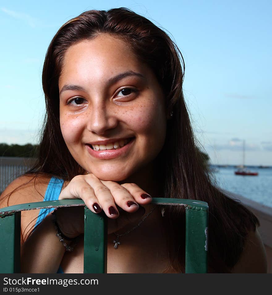 Young smiling female with her head on a fence. Young smiling female with her head on a fence.