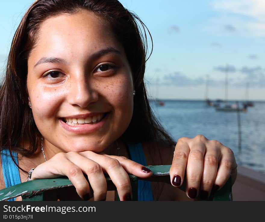 Young smiling female with her head on a fence. Young smiling female with her head on a fence.