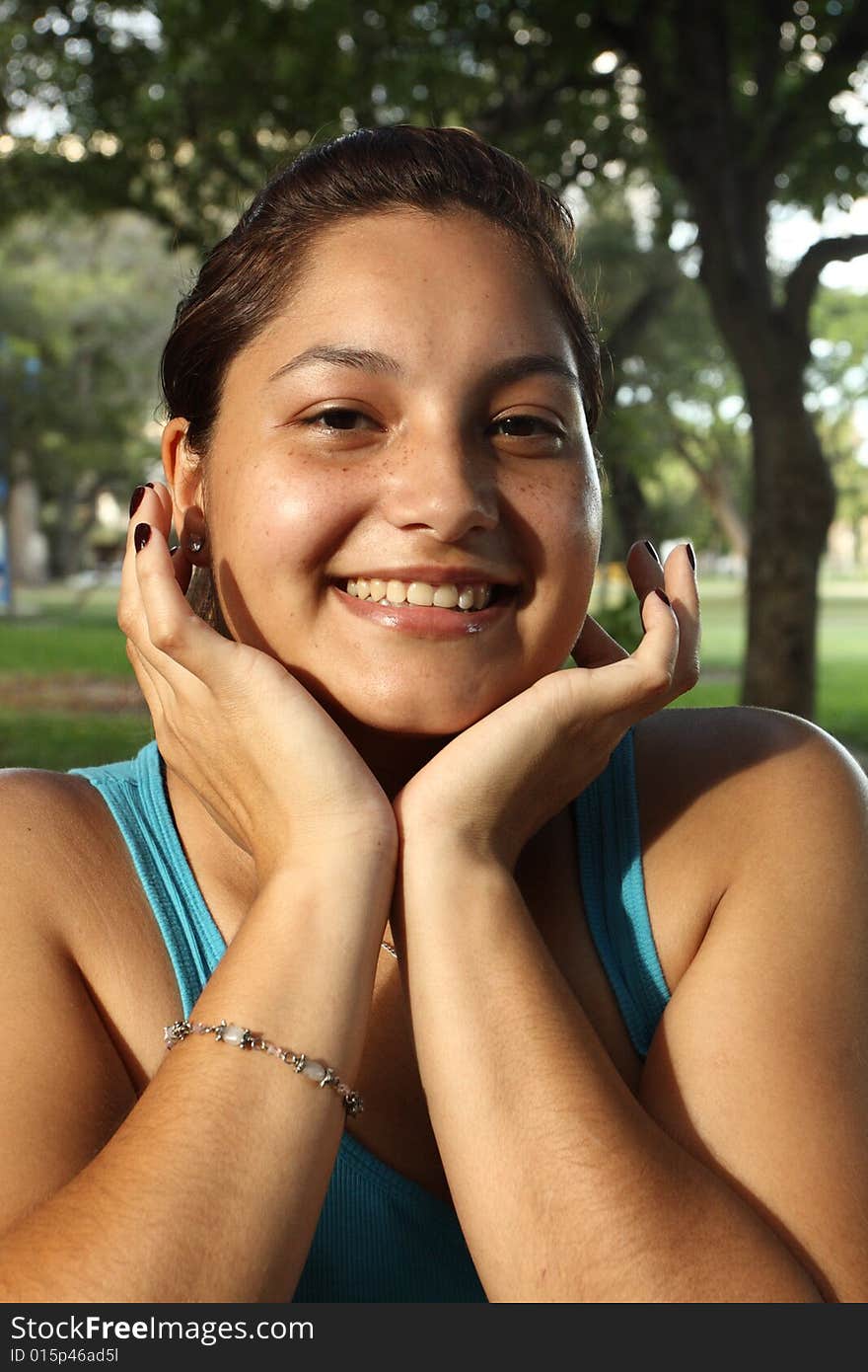 Young woman smiling with her hands under her face. Young woman smiling with her hands under her face