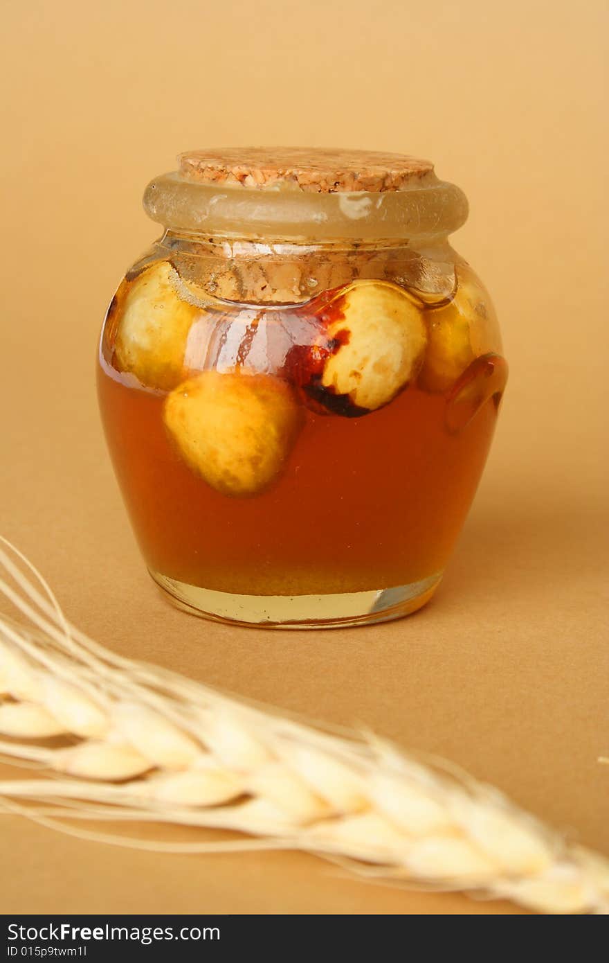 Container with honey and dry fruits and tenon of wheat