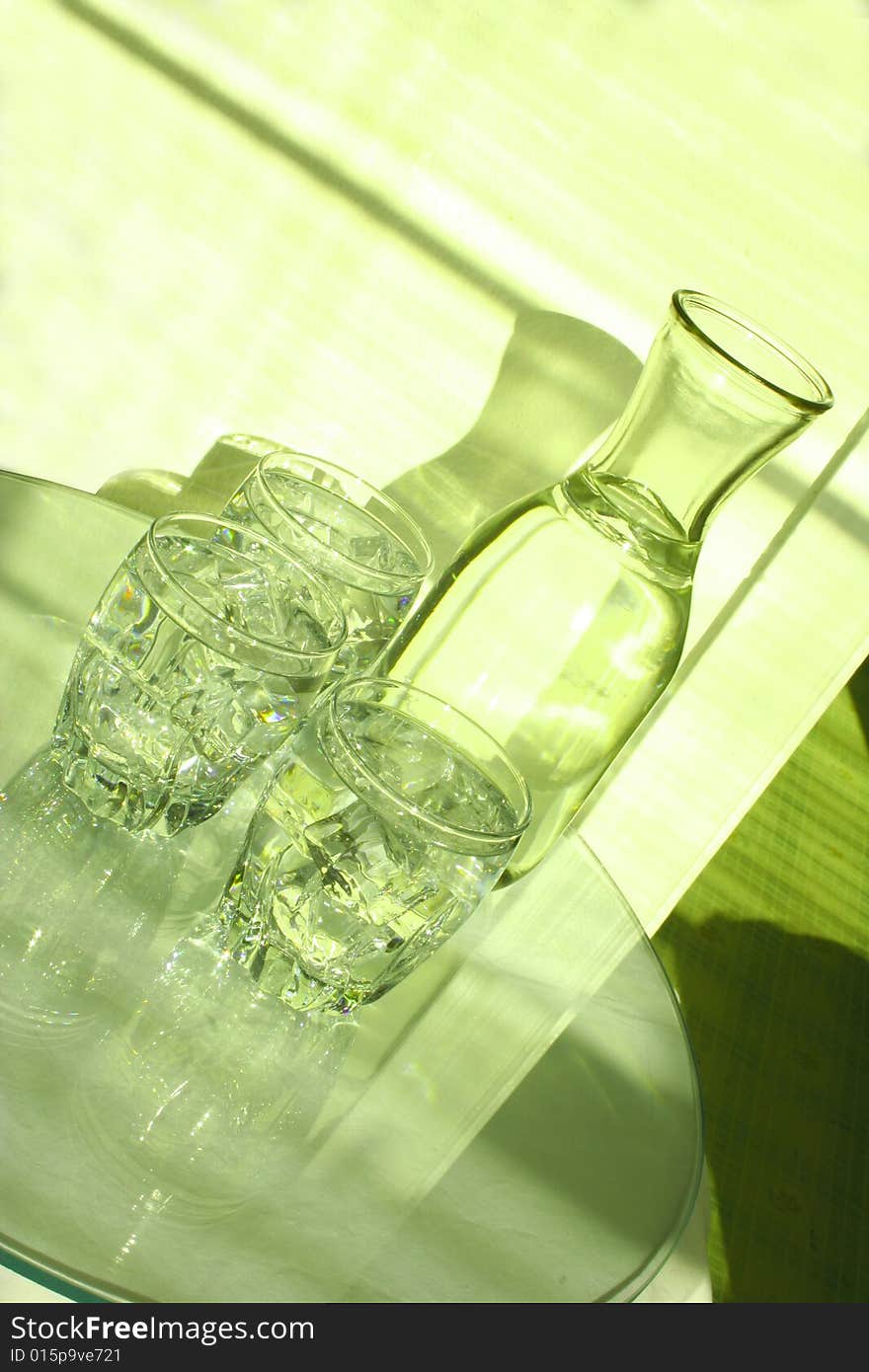 Bottle and glasses of water with ice cubes. Bottle and glasses of water with ice cubes