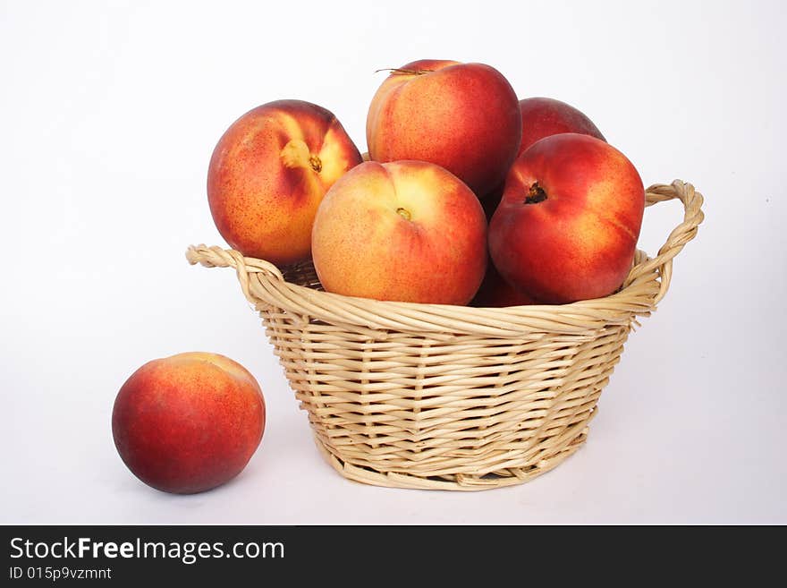 Fresh nectarines in a basket and white background. Fresh nectarines in a basket and white background