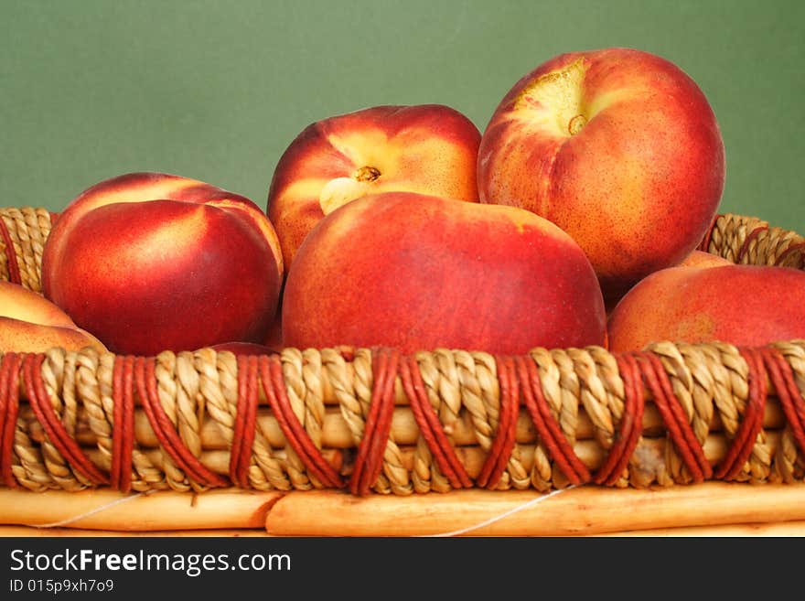 Basket of nectarines in green back ground. Basket of nectarines in green back ground