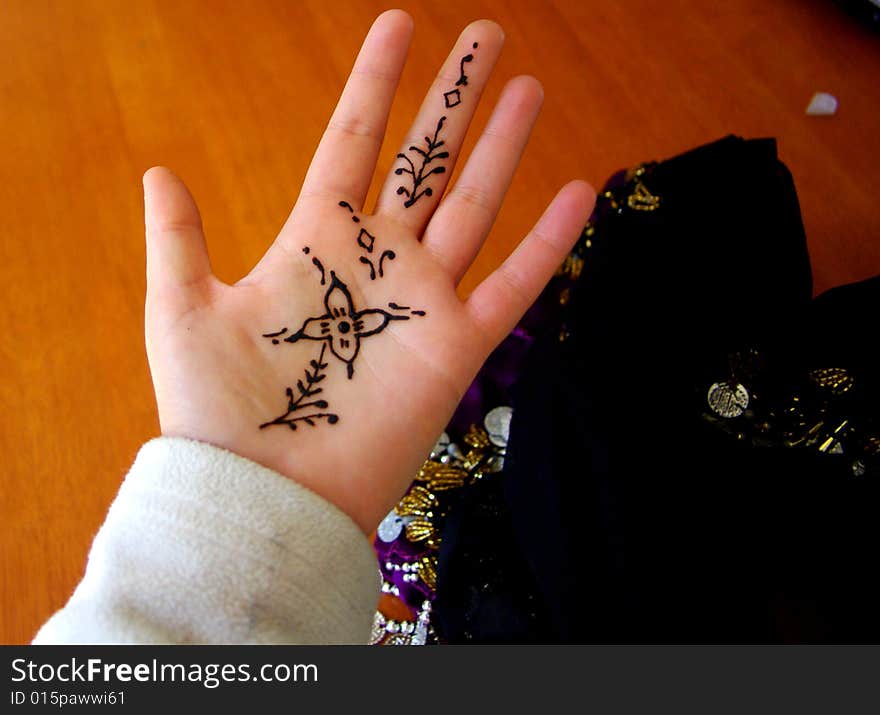 A woman's hand with freshly applied henna, and a bellydancing coin belt (Australia). A woman's hand with freshly applied henna, and a bellydancing coin belt (Australia).