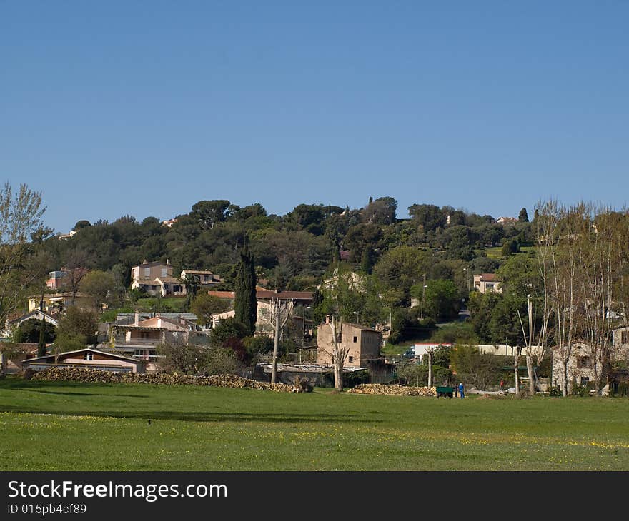 A village on a hill with a field in the foreground