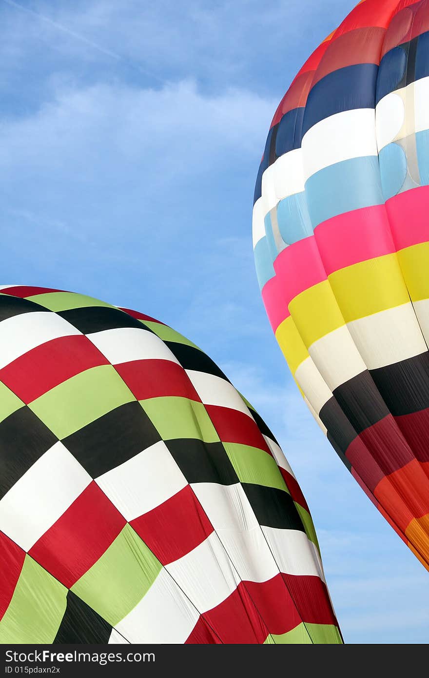 Multi-colored hot air balloons ascending into the clear blue sky