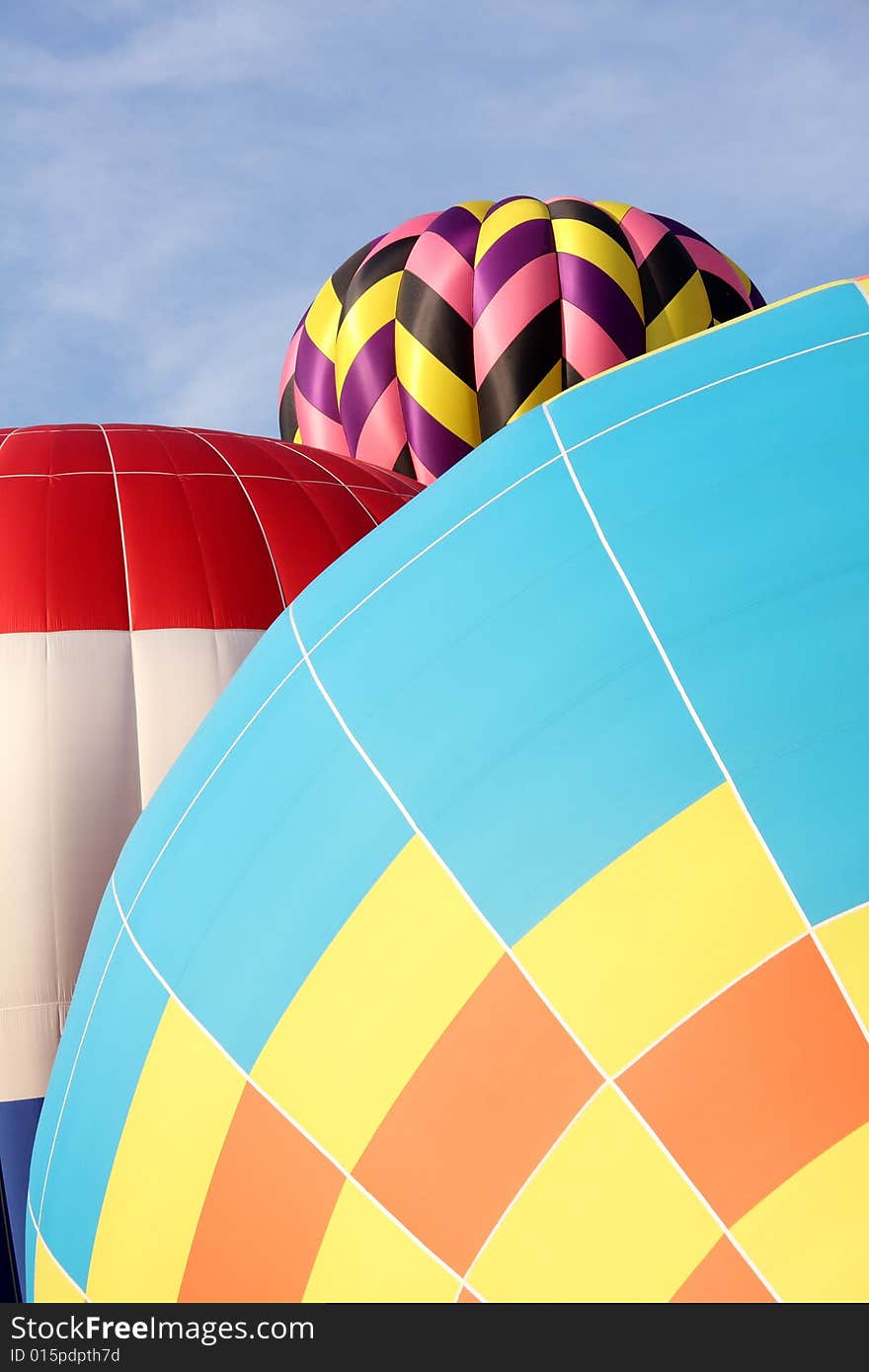 Multi-colored hot air balloons ascending into the clear blue sky