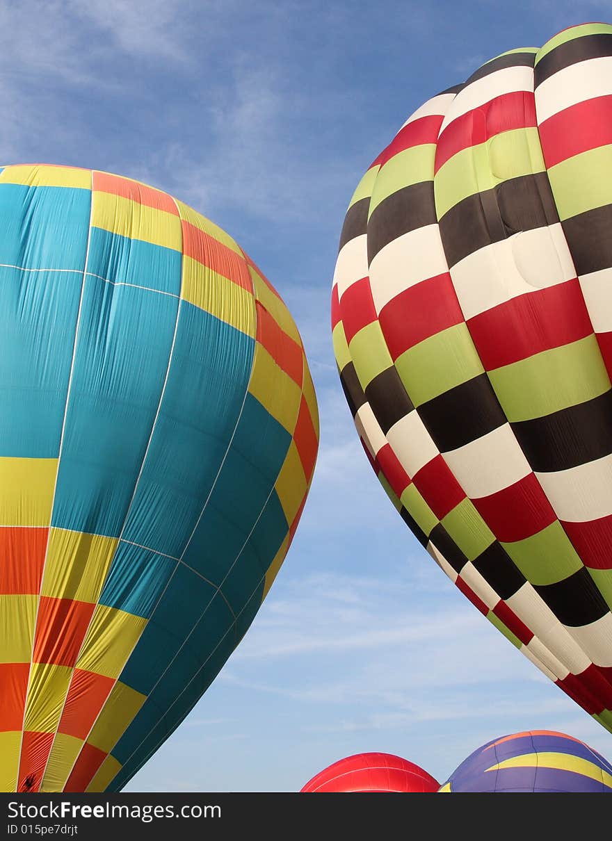 Multi-colored hot air balloons ascending into the clear blue sky