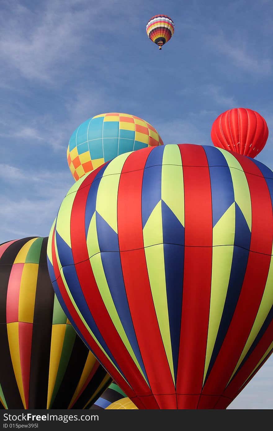 Multi-colored hot air balloons ascending into the clear blue sky