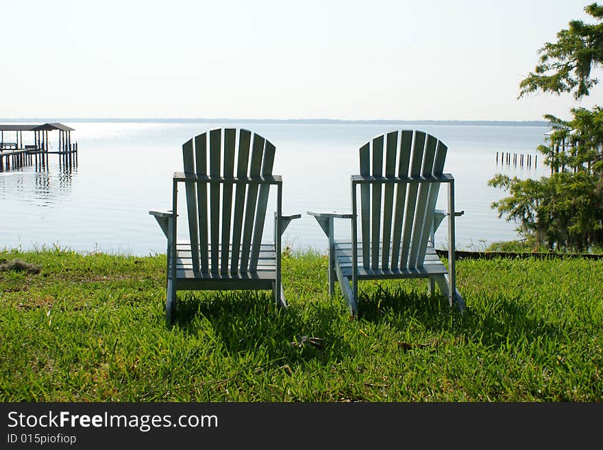 Two Adirondack chairs overlook the peacefulness of the St. John's River. Two Adirondack chairs overlook the peacefulness of the St. John's River.