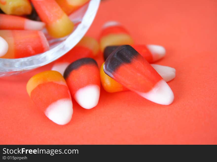 Close up of candy corn spilling out of a candy dish.