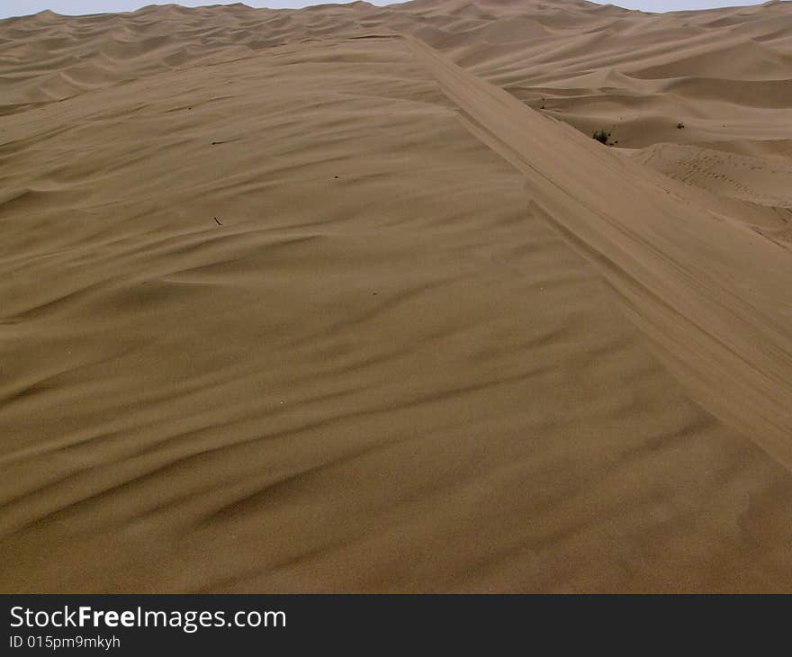 The sand of the dune flowing by wind and shaping a beautiful picture, in Kumutage desert. The sand of the dune flowing by wind and shaping a beautiful picture, in Kumutage desert.