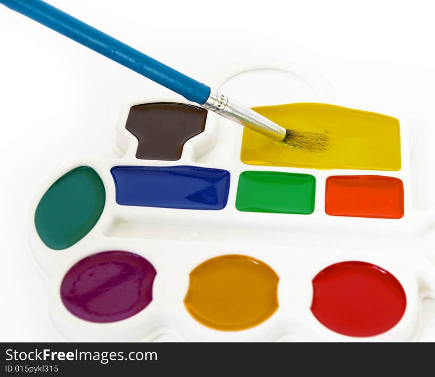 Box of watercolors and a brush isolated on a white background.