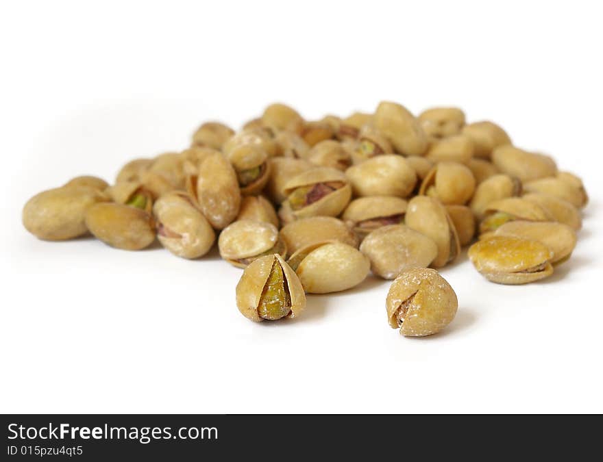 Heap of salty pistachios isolated. Soft focus