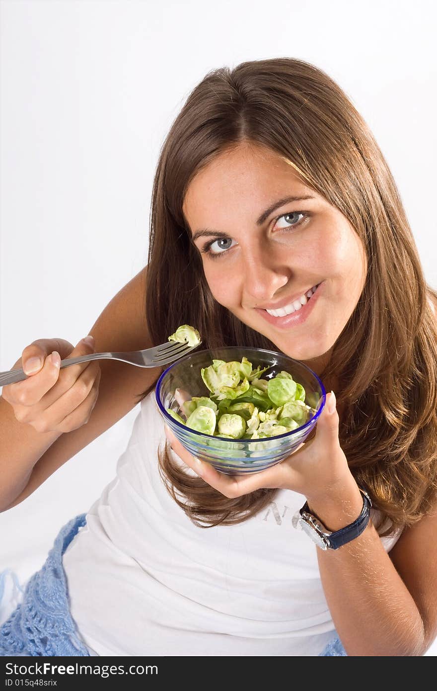 Portrait of young happy smiling woman eating salad