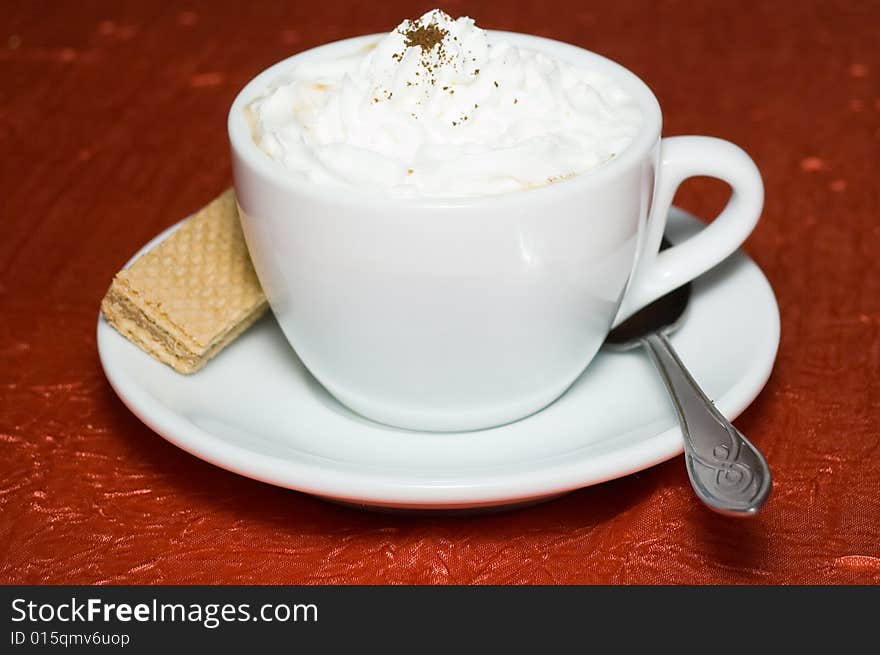 Cup of cappuccino strewed by grated chocolate