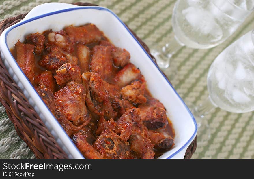 Oriental hot and spicy chili pork rib pieces with ice water. Oriental hot and spicy chili pork rib pieces with ice water