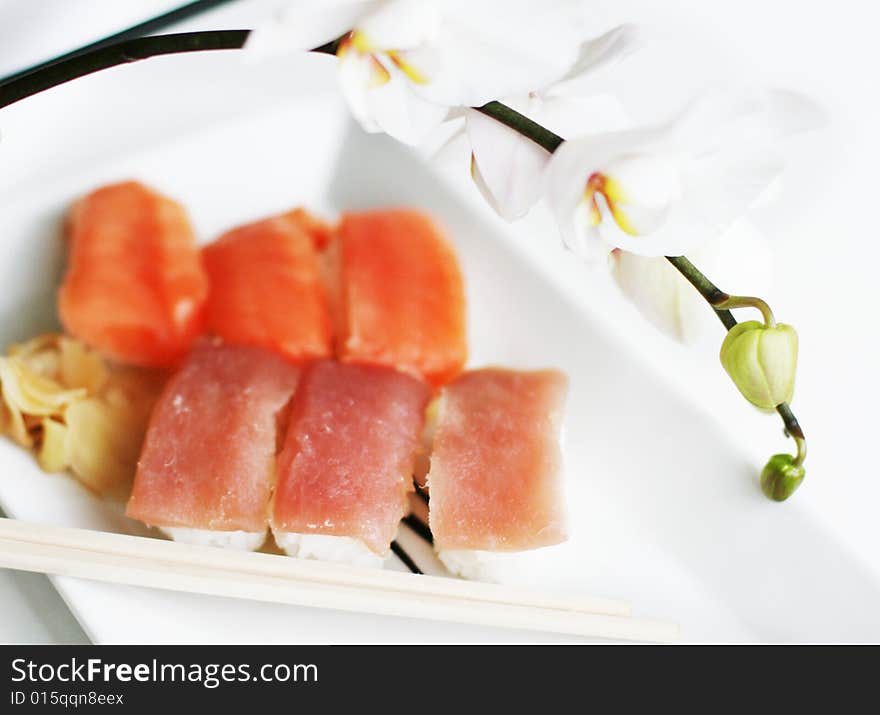 Sushi plate with chopsticks and orchid around