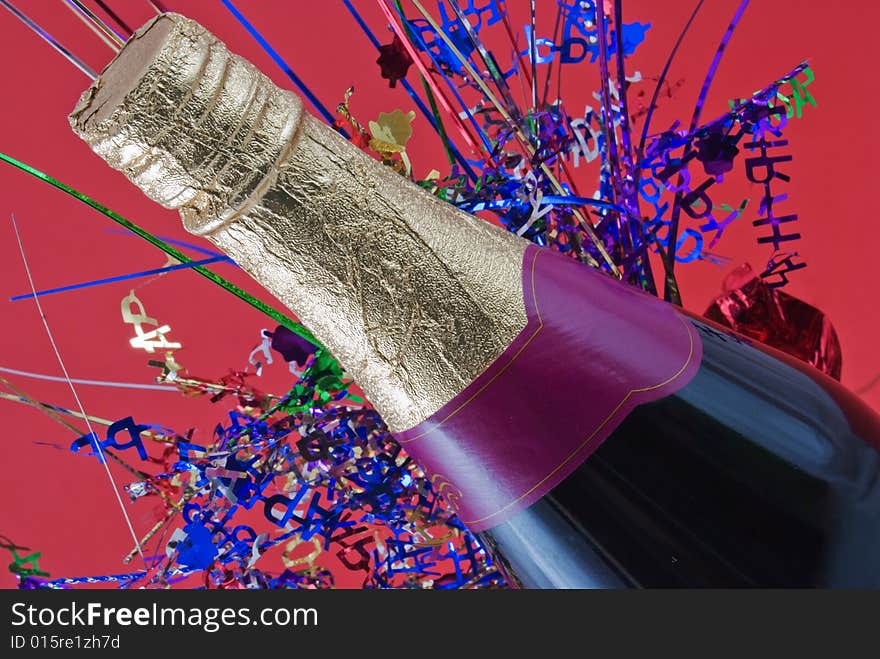 Champagne bottle with colored confetti behind. Champagne bottle with colored confetti behind