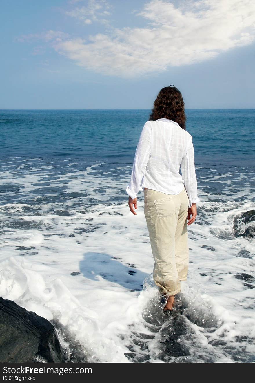 Woman standing on a black sand beach on Big Island, Hawaii. Woman standing on a black sand beach on Big Island, Hawaii