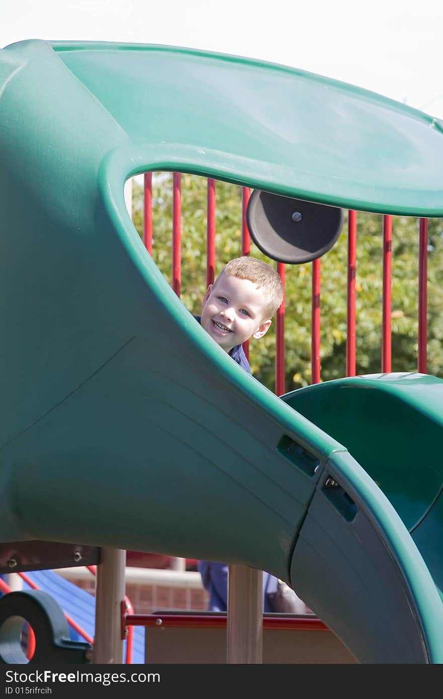 Young child playing at the park play ground on a beautiful summer day. Young child playing at the park play ground on a beautiful summer day