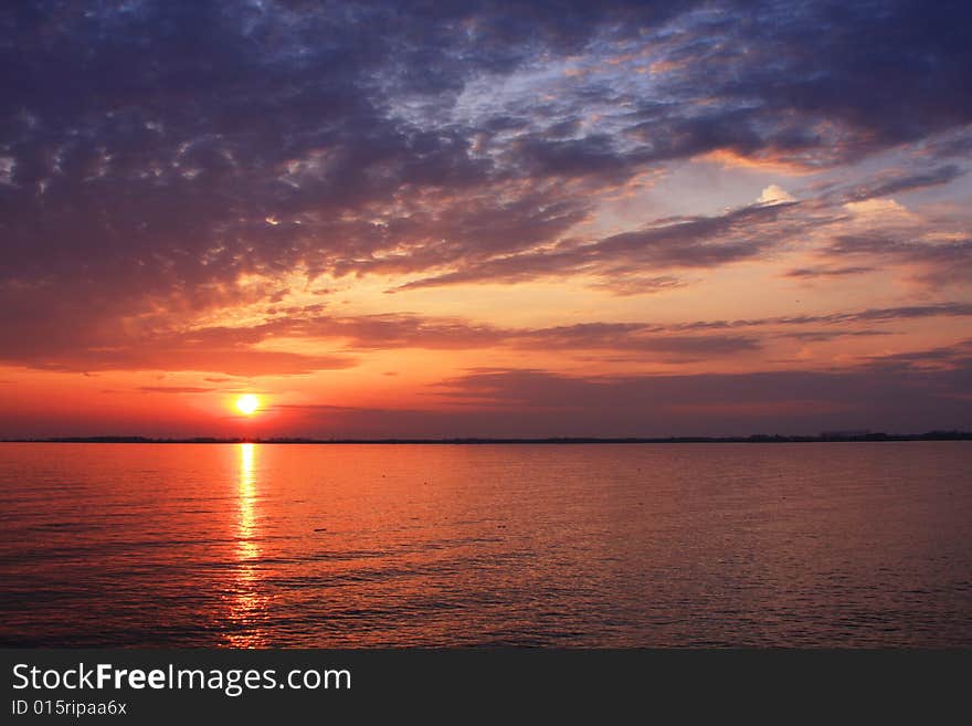 The sun sets over Lake Ontario illuminating the sky in a spray of color. The sun sets over Lake Ontario illuminating the sky in a spray of color.