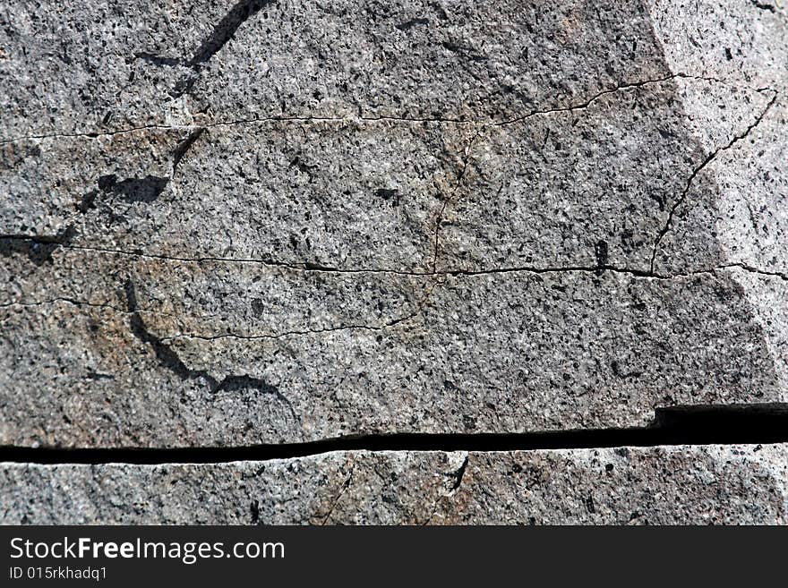 A cracked and worn rock face with deep rivet. A cracked and worn rock face with deep rivet.